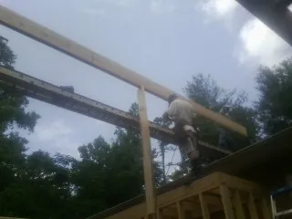Carpenter setting a ridge beam over a new addition frame — Ice Dam Removal by Roofing Brothers in Sale City