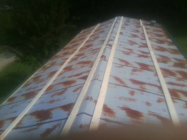 Rusted metal roof panels with new wood purlins before replacement — Storm Damage Roof Repair in Sale City by Roofing Brothers